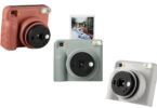 Trois appareils photo instantanés Fujifilm instax SQUARE 2 en rouge brique, bleu ardoise et blanc brumeux, avec un tirage carré sortant de l'appareil bleu