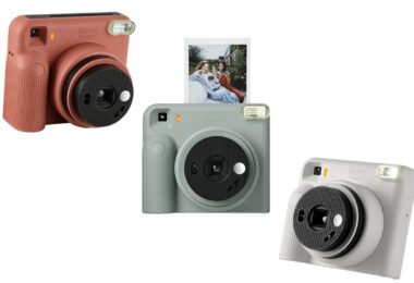 Trois appareils photo instantanés Fujifilm instax SQUARE 2 en rouge brique, bleu ardoise et blanc brumeux, avec un tirage carré sortant de l'appareil bleu
