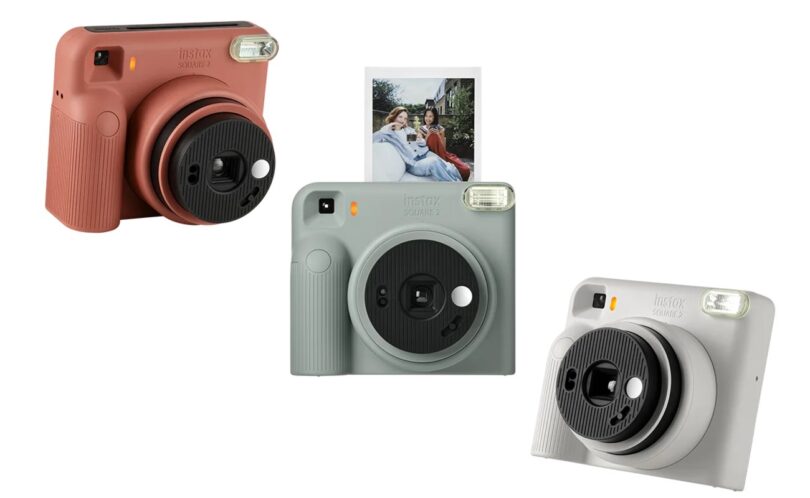 Trois appareils photo instantanés Fujifilm instax SQUARE 2 en rouge brique, bleu ardoise et blanc brumeux, avec un tirage carré sortant de l'appareil bleu