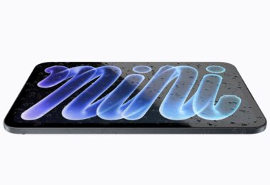 Le nouvel iPad mini 2026 à écran OLED de 8,5 pouces posé à plat et couvert de gouttes d'eau, illustrant sa certification IP67 contre l'eau et la poussière