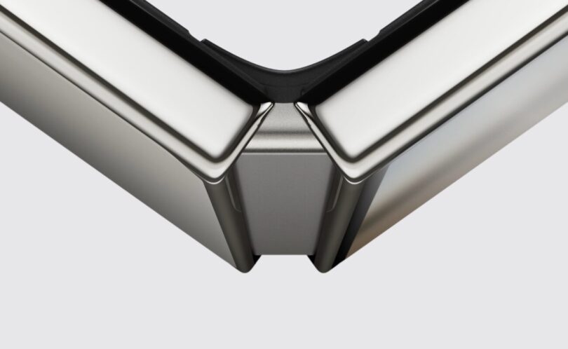Gros plan officiel sur la charnière de l'iPhone Duo entrouvert, avec ses deux moitiés en aluminium et le bloc central qui soutient l'écran intérieur pliant