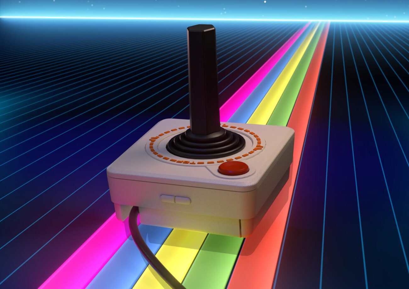 Joystick THECXSTICK de THE 800XL, inspiré du CX40 d'Atari avec manche noir et bouton rouge, posé sur un décor de bandes arc-en-ciel lumineuses