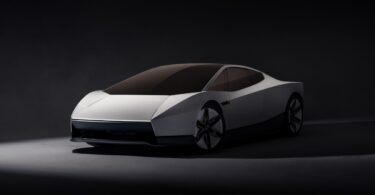 Nouveau Tesla Roadster présenté le 15 octobre 2026, vu de trois quarts avant en peinture blanche, avec phares dissimulés et ligne de coupé deux places