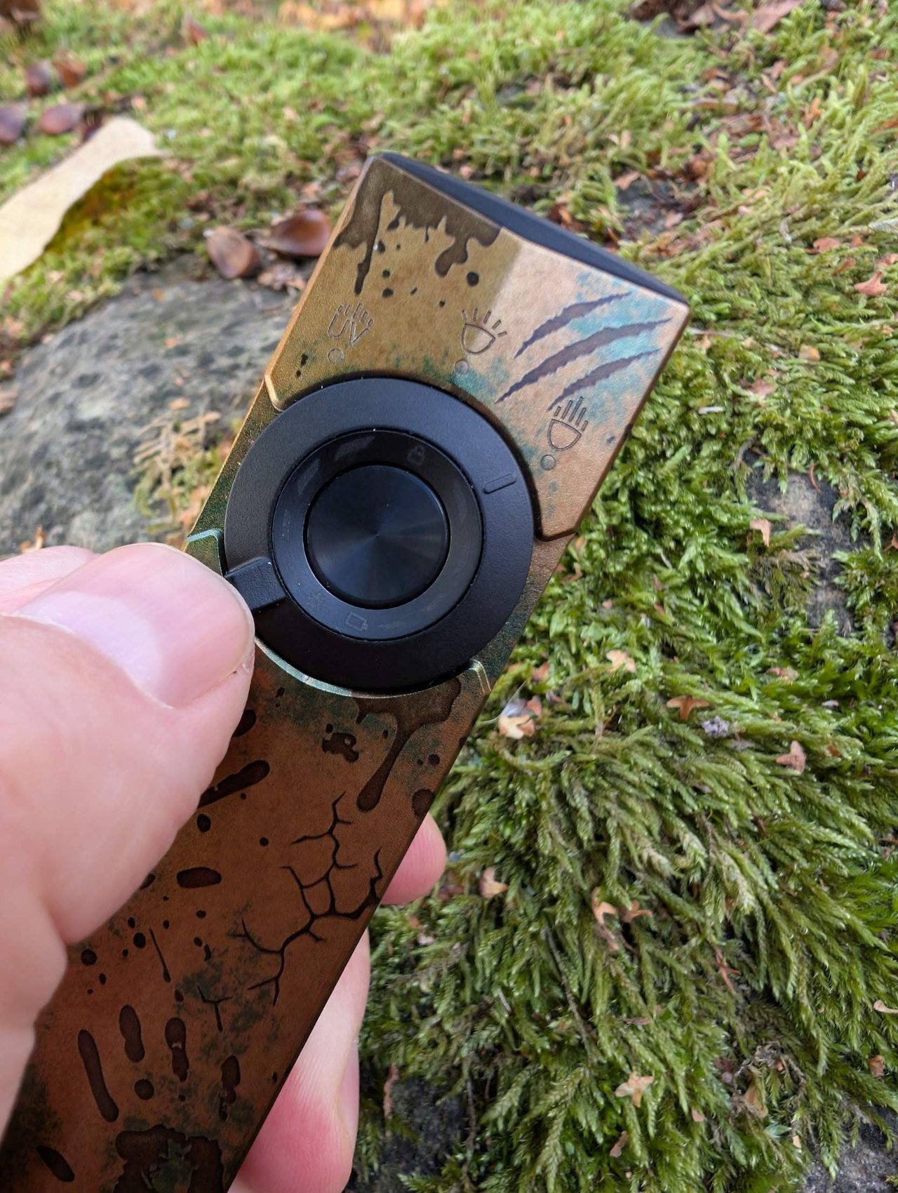 Gros plan sur l'édition Relique des terres désolées de l'Olight ArkPro : griffures, éclaboussures et repères UV, Pure Flood et Spot