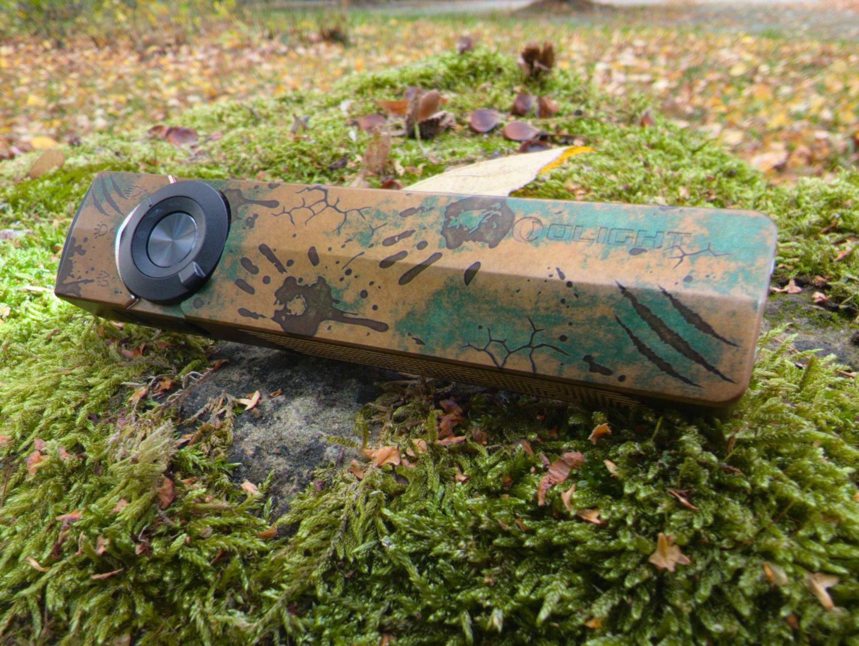 Olight ArkPro Ultra vue de trois quarts : nervure centrale, grip strié et finition Relique des terres désolées