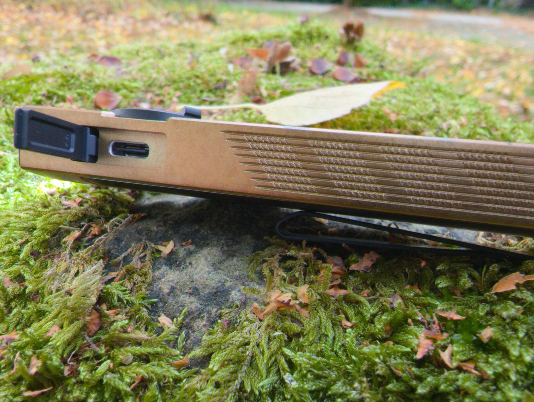 Tranche de l'Olight ArkPro Ultra avec la trappe ouverte sur le port USB-C