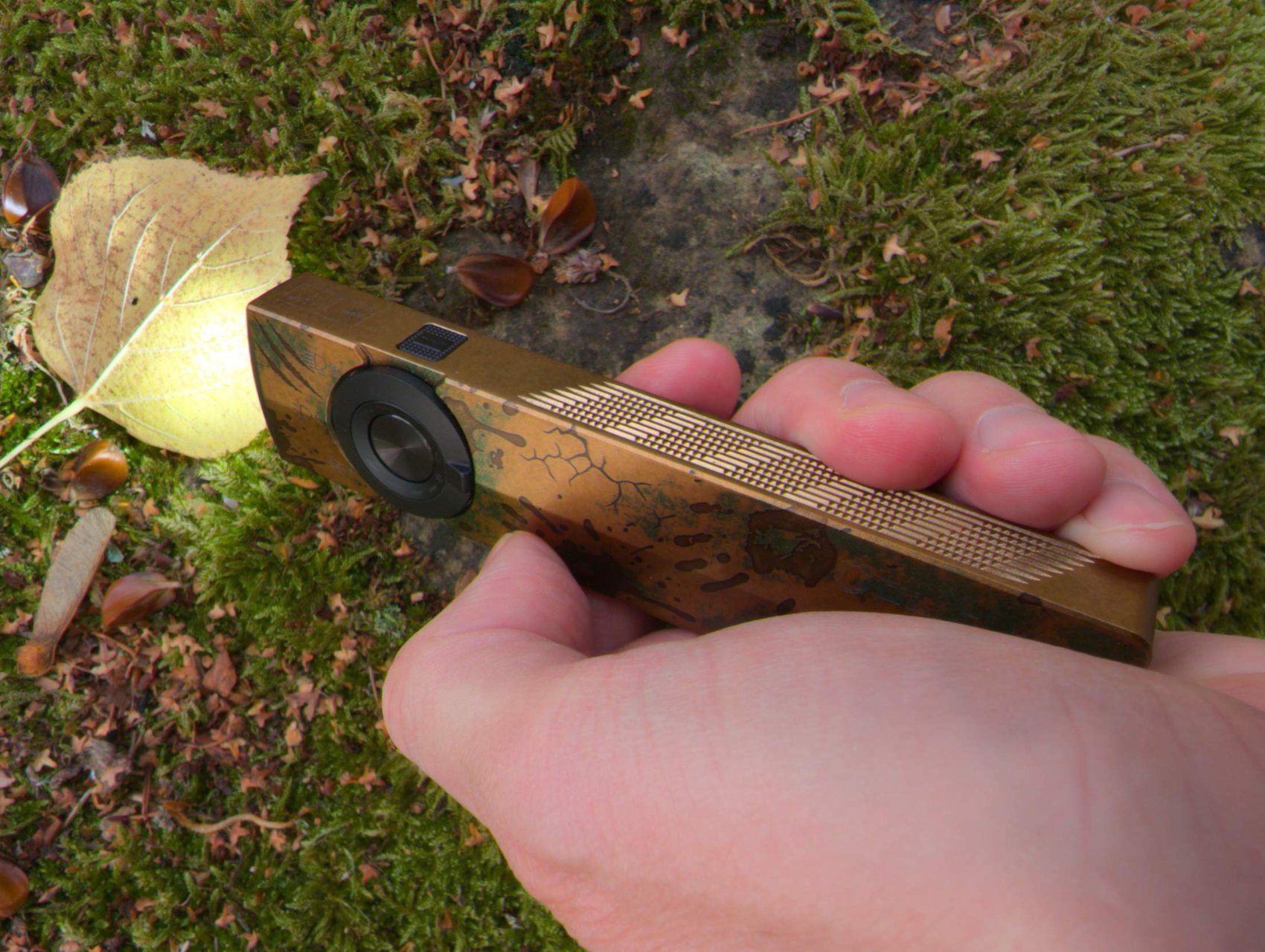 Prise en main de l'Olight ArkPro Ultra : la lampe plate tient dans le creux de la main, doigts sur le grip strié