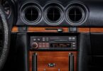 Autoradio rétro Pioneer SXT-C10PS installé dans la console centrale boisée d'une Mercedes 280 SL R107 de 1980, éclairage orange