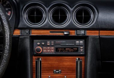 Autoradio rétro Pioneer SXT-C10PS installé dans la console centrale boisée d'une Mercedes 280 SL R107 de 1980, éclairage orange