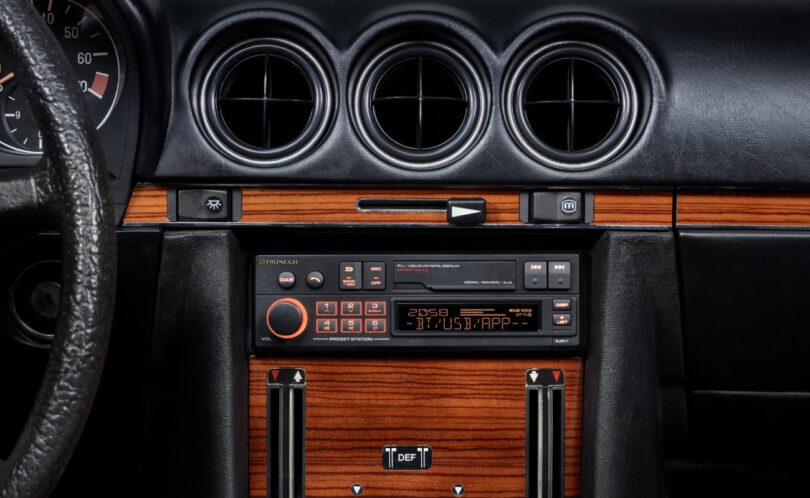 Autoradio rétro Pioneer SXT-C10PS installé dans la console centrale boisée d'une Mercedes 280 SL R107 de 1980, éclairage orange