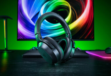 Casque gaming sans fil Razer Barracuda V2 Pro noir posé sur un bureau devant un écran coloré, avec clavier et souris Razer en arrière-plan