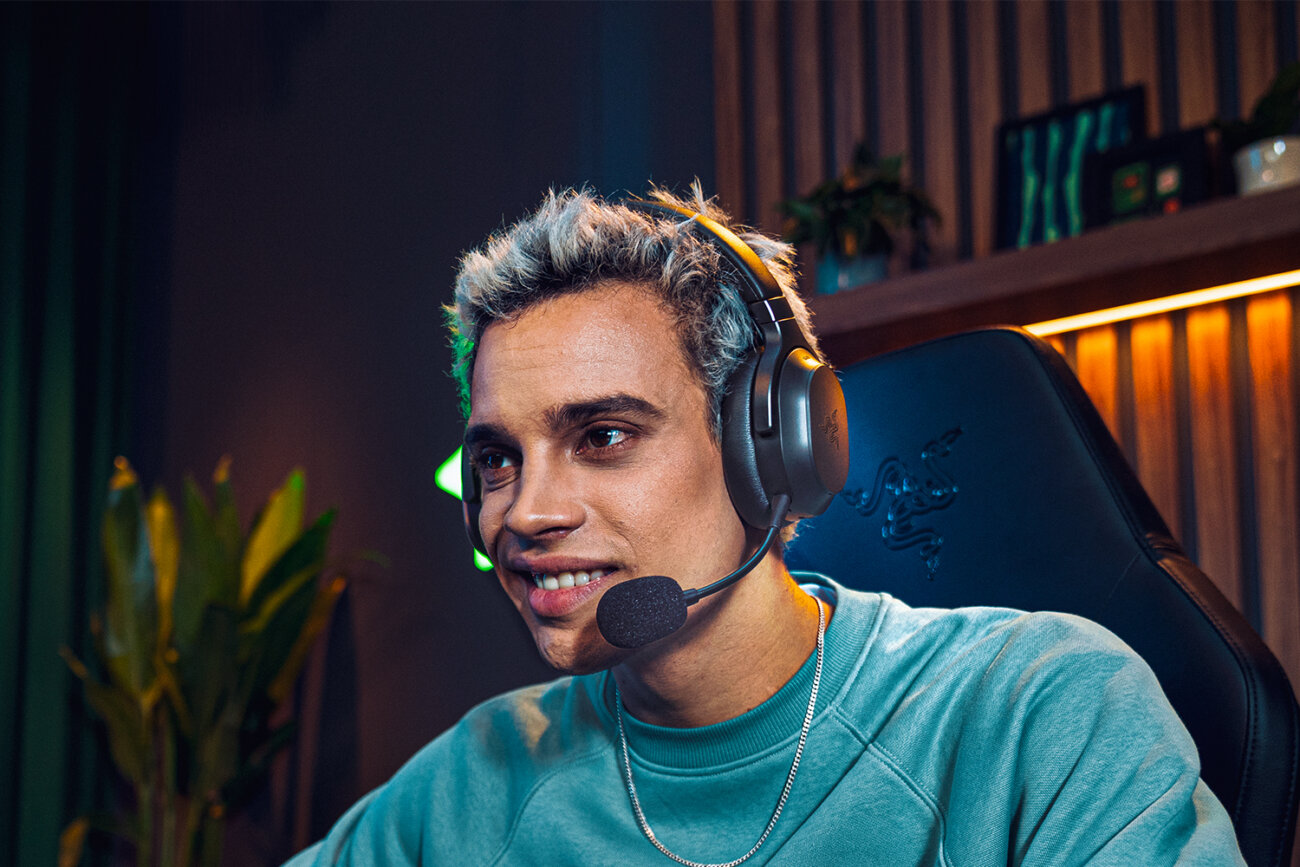 Joueur portant le casque Razer Barracuda V2 Pro avec son micro perche amovible, assis dans un fauteuil gaming