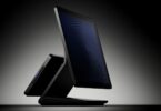 Caisse Revolut Register noire vue de profil sur fond sombre, avec son grand écran tactile côté commerçant et le second écran orienté vers le client