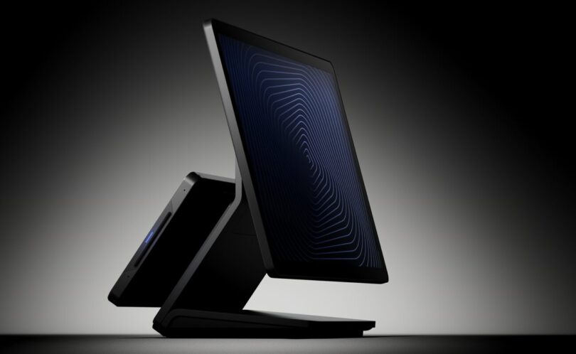 Caisse Revolut Register noire vue de profil sur fond sombre, avec son grand écran tactile côté commerçant et le second écran orienté vers le client