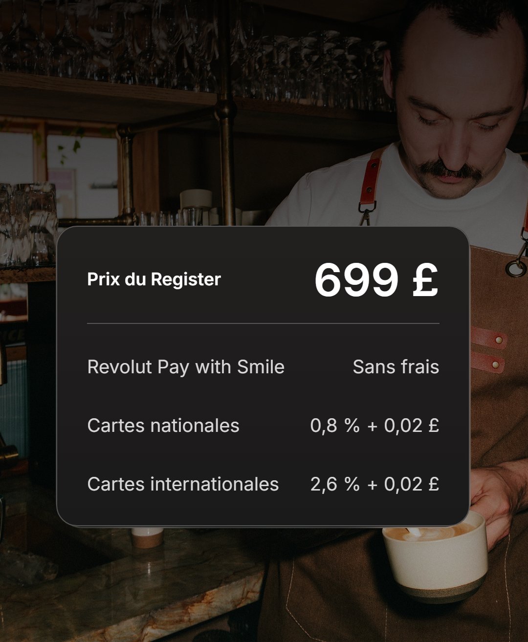 Barista servant un café derrière un encadré traduit en français : prix du Register 699 £, Revolut Pay with Smile sans frais, cartes nationales 0,8 % + 0,02 £, cartes internationales 2,6 % + 0,02 £