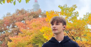 Homme portant les écouteurs ouverts à clip Samsung Galaxy Buds On noirs dans un parc en automne, conduit auditif libre
