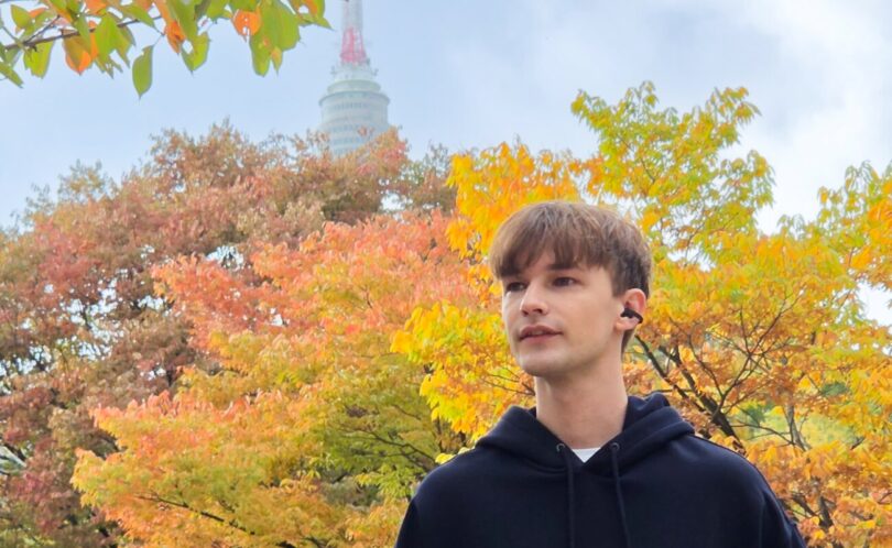 Homme portant les écouteurs ouverts à clip Samsung Galaxy Buds On noirs dans un parc en automne, conduit auditif libre
