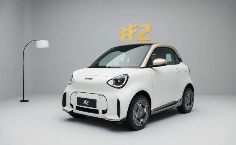 La smart #2 électrique deux places en finition Couture Edition, carrosserie blanche et toit doré, photographiée en studio de trois quarts avant