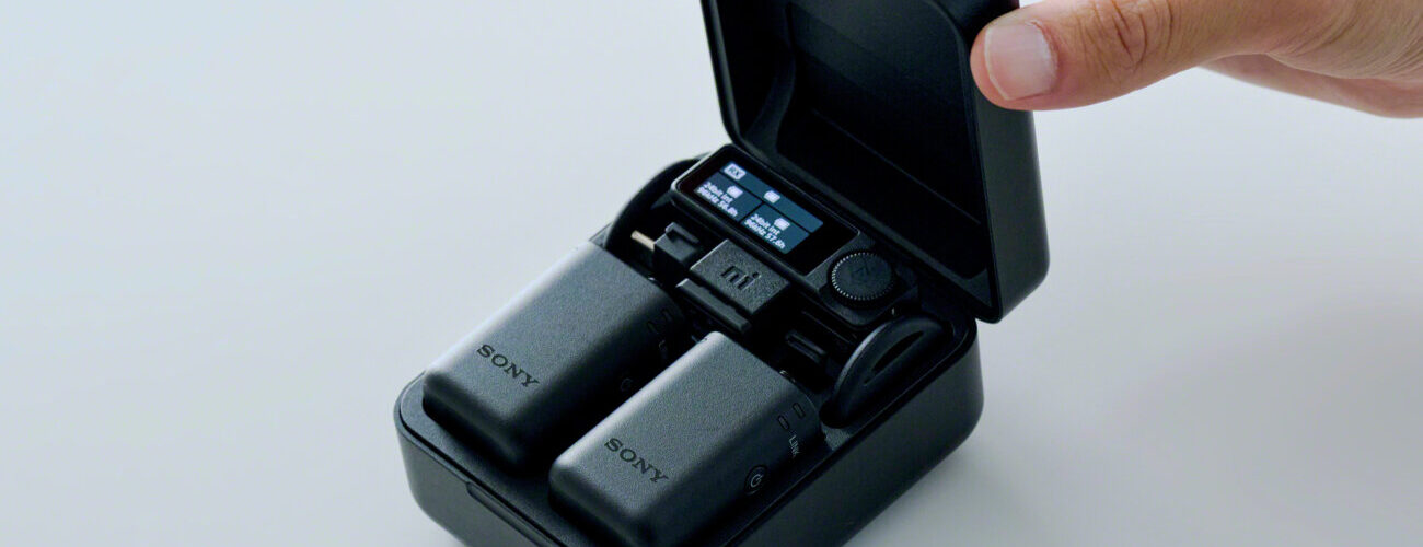 Kit de micros sans fil Sony ECM-W5 dans son étui de charge ouvert, avec les deux émetteurs noirs et le récepteur à écran, posé sur une table claire