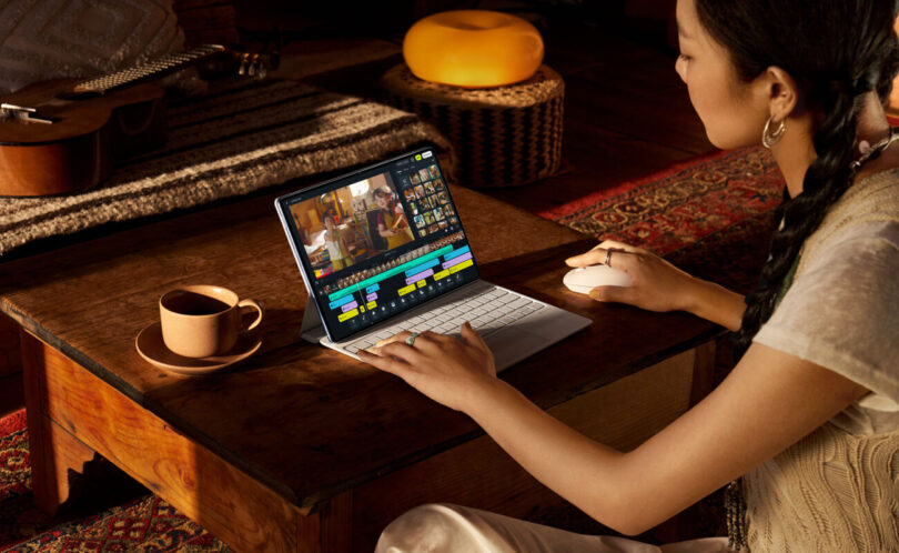 Femme utilisant la tablette Huawei MatePad Pro 12 (2026) posée sur son clavier Glide Keyboard pour du montage vidéo, sur une table basse en bois