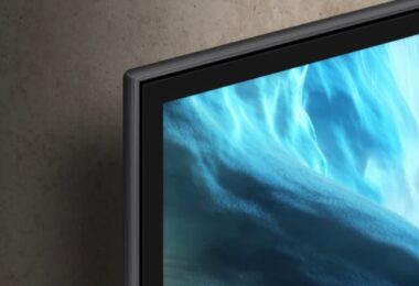 Bord ultrafin d'un téléviseur OLED Samsung Vision AI 2026 fixé au mur, écran affichant des vagues bleues abstraites, illustration des TV connectées concernées par la question de la télémétrie